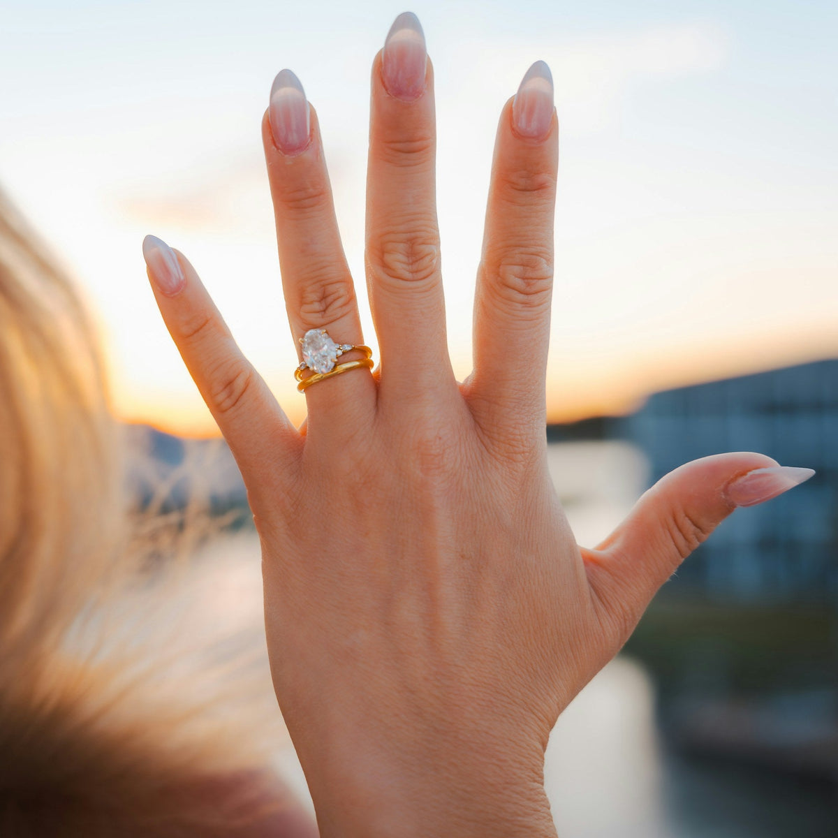 Diamond engagement ring on a hand at sunset